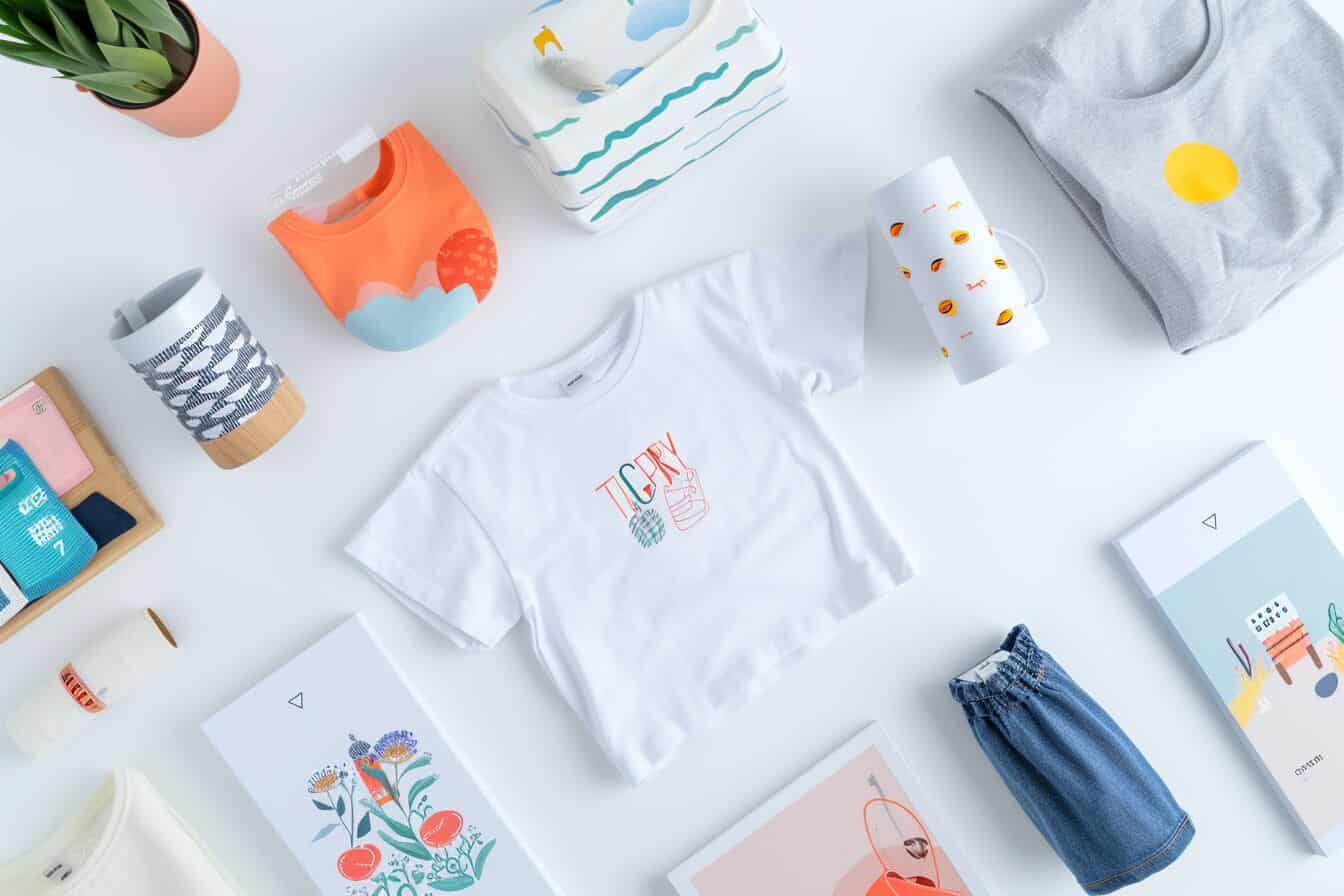 Overhead view of print-on-demand products with unique AI-generated designs on a T-shirt, mug, and poster, showcasing creativity in merchandise design.